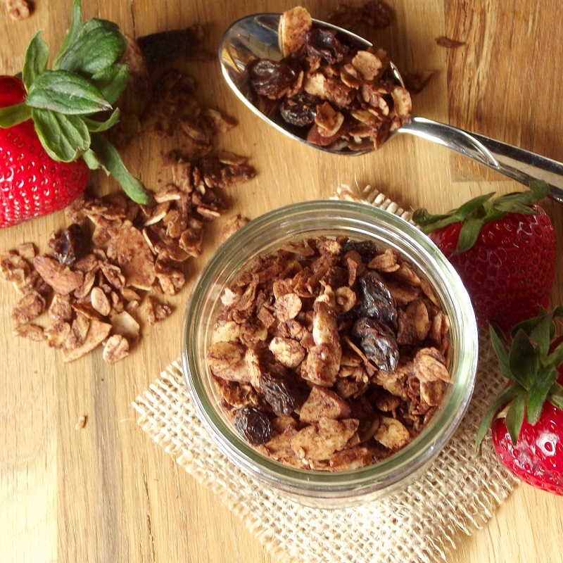 Overhead View of a Wooden Surface Set with Jar of Chocolate Granola, Spoon and Strawberries