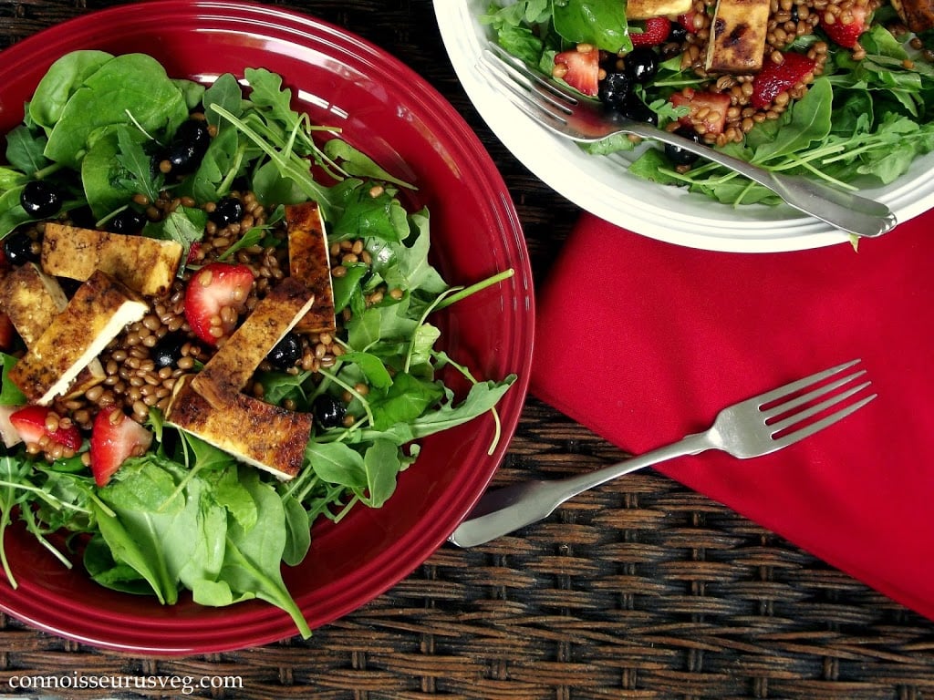 Two Plates of Salad on a Wicker Surface with Red Napkin and Fork