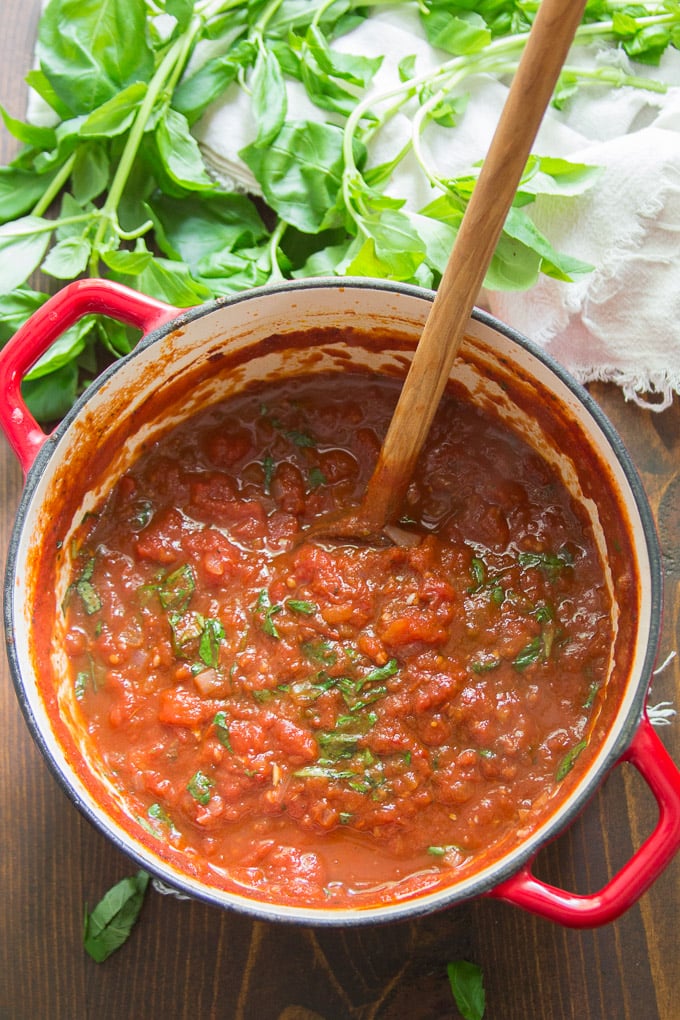 Pot of Marinara Sauce with a Bunch of Basil on the Side