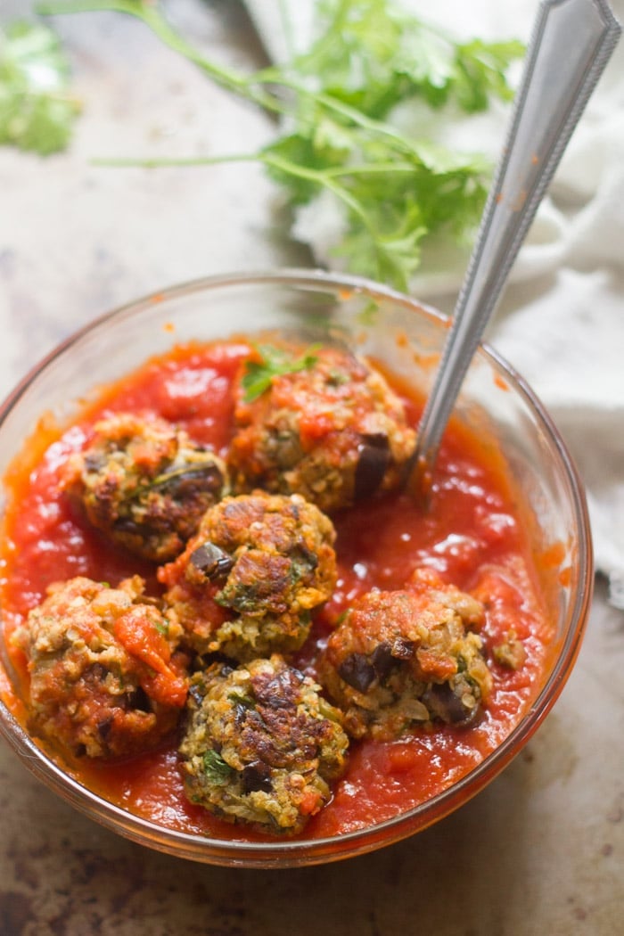 Eggplant Meatballs in a Bowl with Tomato Sauce and Serving Spoon