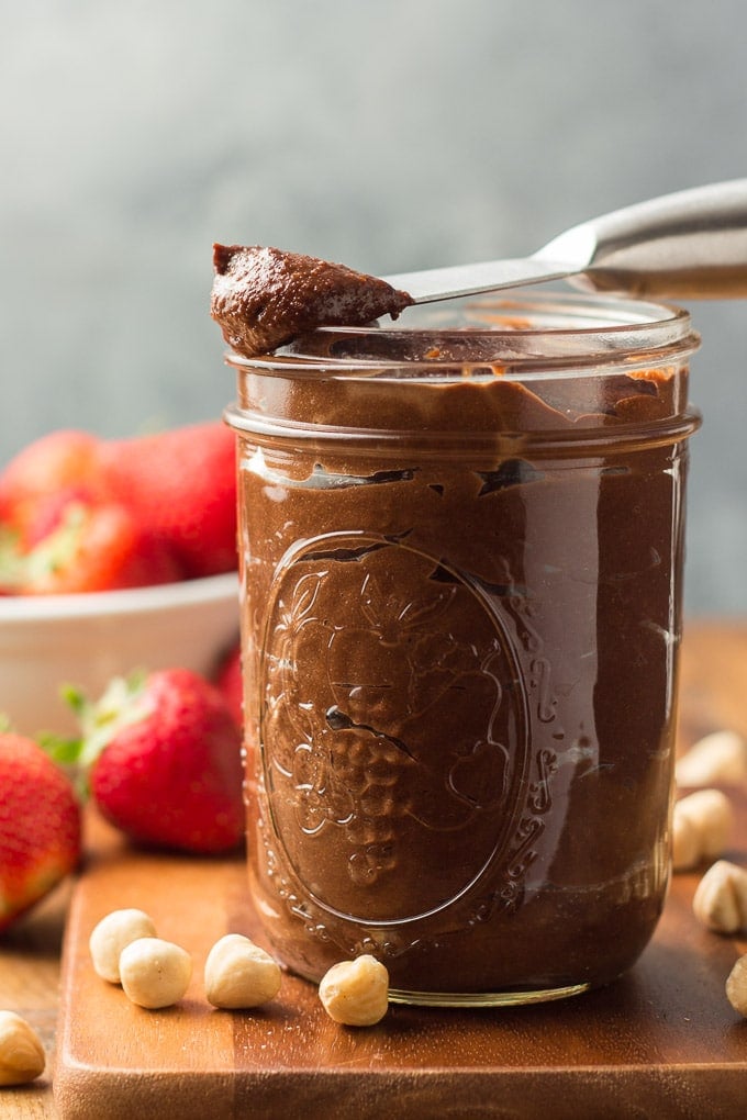 Side View of a Jar of Vegan Nutella with Spreader Perched on Top