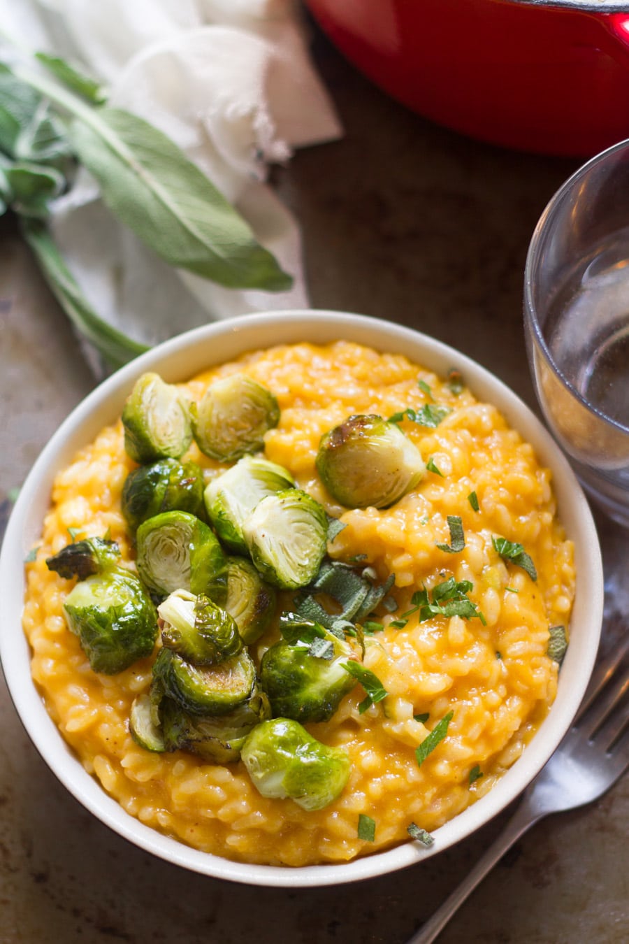 Bowl of Butternut Squash Risotto and Roasted Brussels Sprouts Topped with Fresh Sage