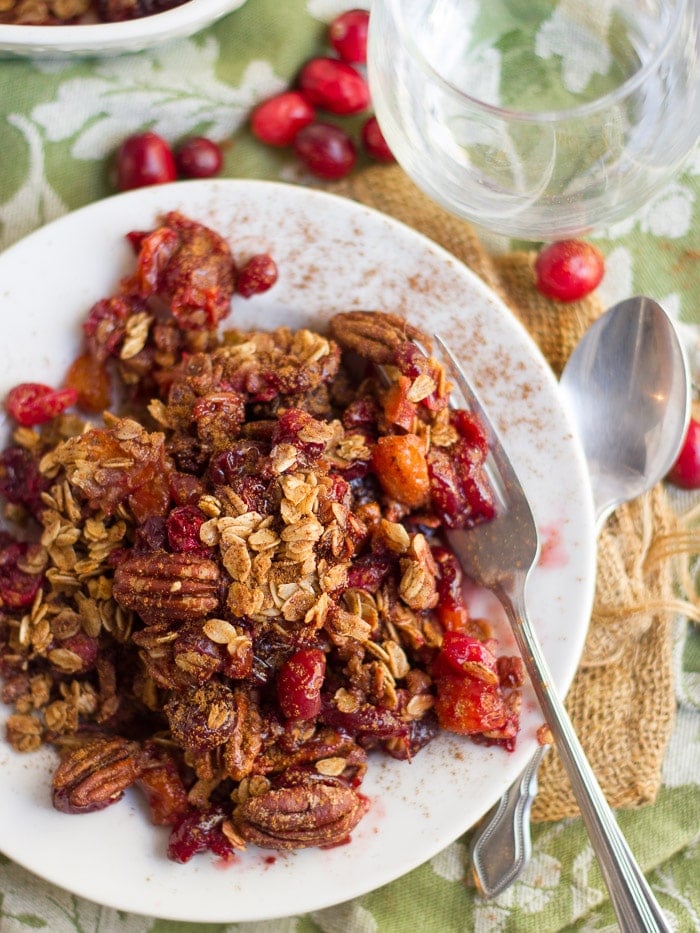 Orange Cranberry Crisp on a Plate with Fork, Spoon and Water Glass