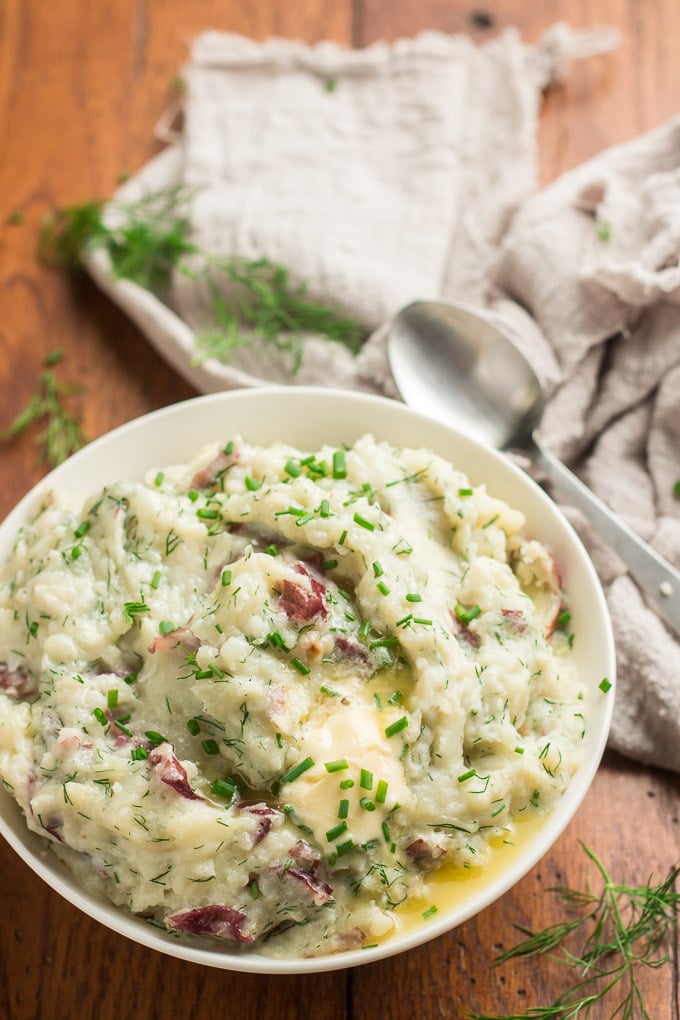 Bowl of Mashed Red Potatoes with Roasted Garlic & Dill with Napkin and Spoon in the Background