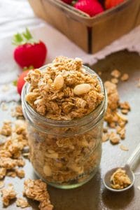 Jar of Peanut Butter Granola with Strawberries in the Background