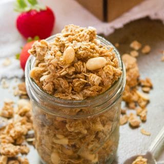 Jar of Peanut Butter Granola with Strawberries in the Background