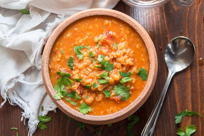 Mediterranean Red Lentil Soup in a Bowl with Spoon and Drinking Glass