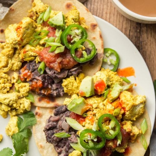 Close Up of Two Vegan Huevos Rancheros Topped with Salsa and Jalapeno Peppers