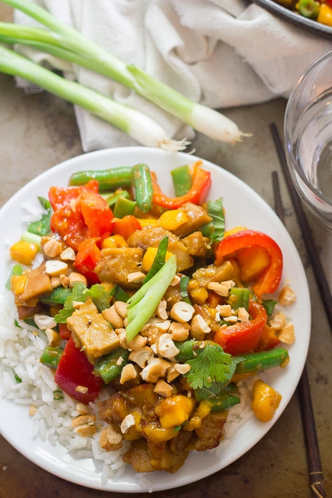 Vegan Mango Chicken Stir-Fry on a Plate with Rice, Water Glass and Scallions