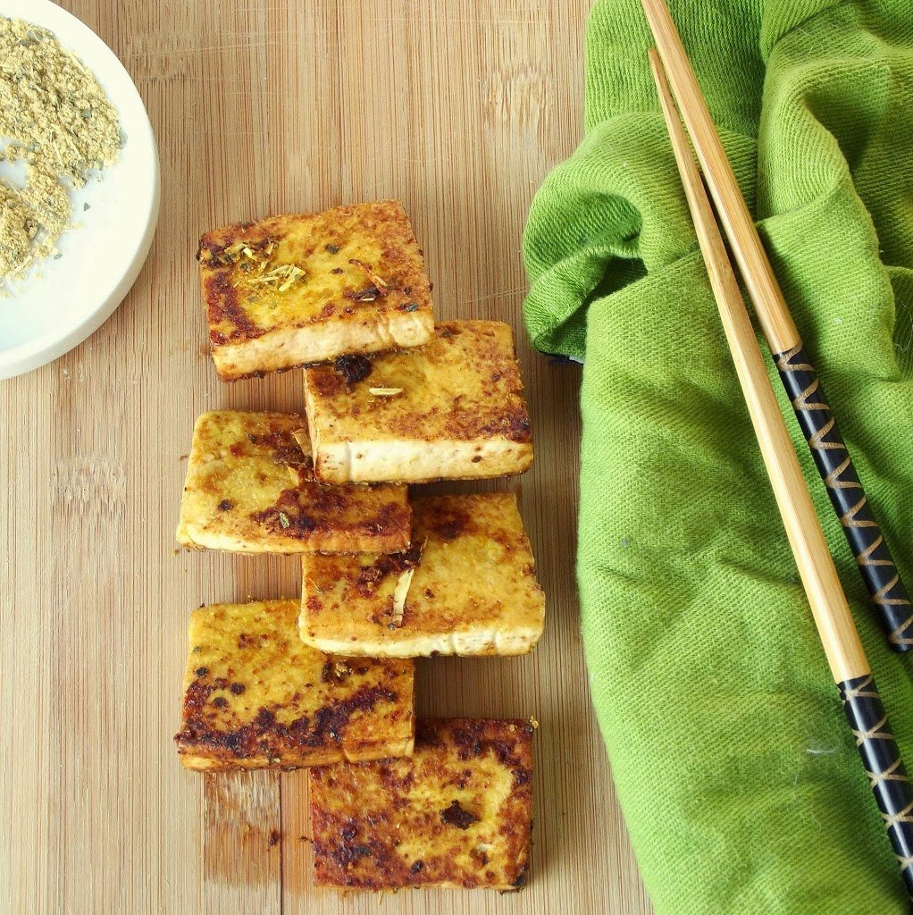 Tofu Squares on a Wooden Surface with Green Napkin and Chopsticks on the Side