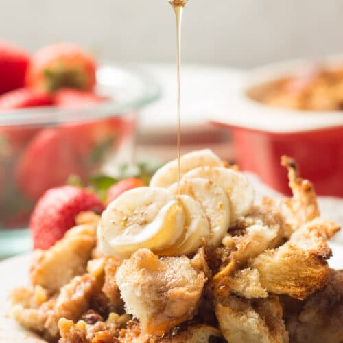 Spoon Drizzling Maple Syrup Over a Piece of Vegan French Toast Casserole