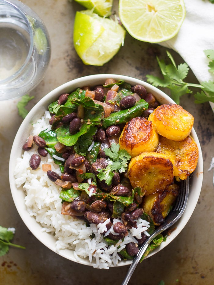 Black Beans and Rice with Collard Greens and Pan-Fried Plantains in a Bowl on a Rustic Surface