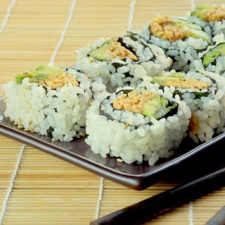 Close Up of Peanut Avocado Sushi on a Plate Sitting on a Sushi Mat