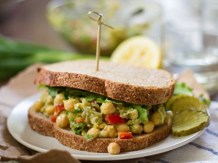 Smashed Chickpea Salad Sandwich on a Plate with Skewer