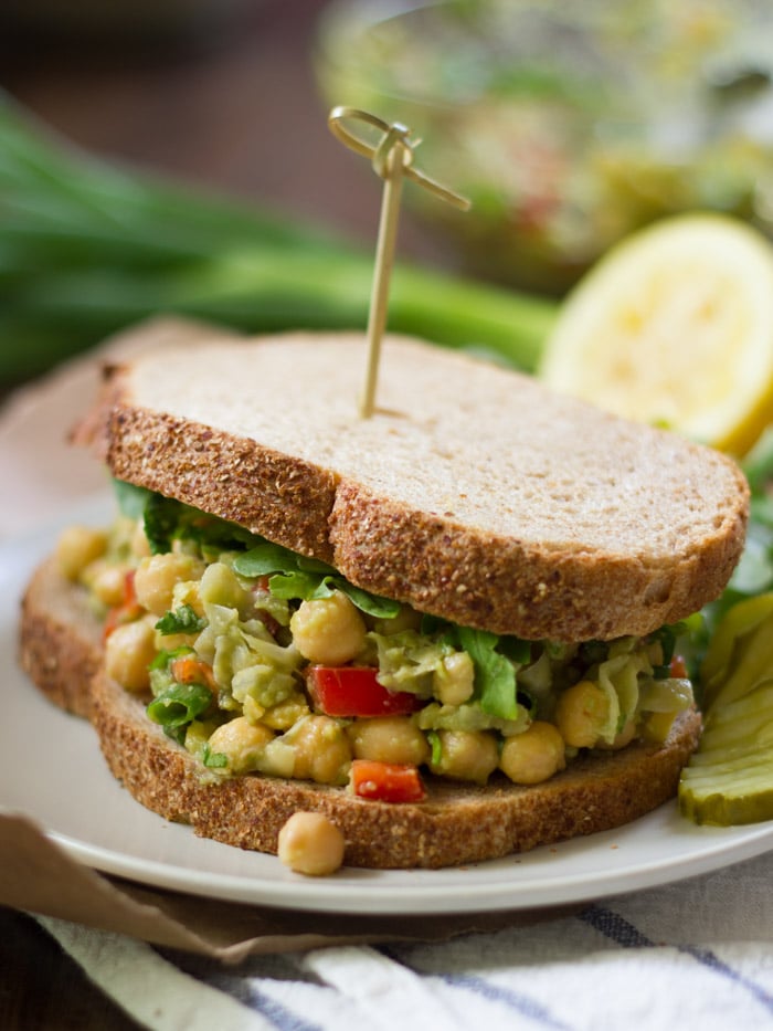 Chickpea Sandwich on a Plate with Scallions and Lemon Half in the Background