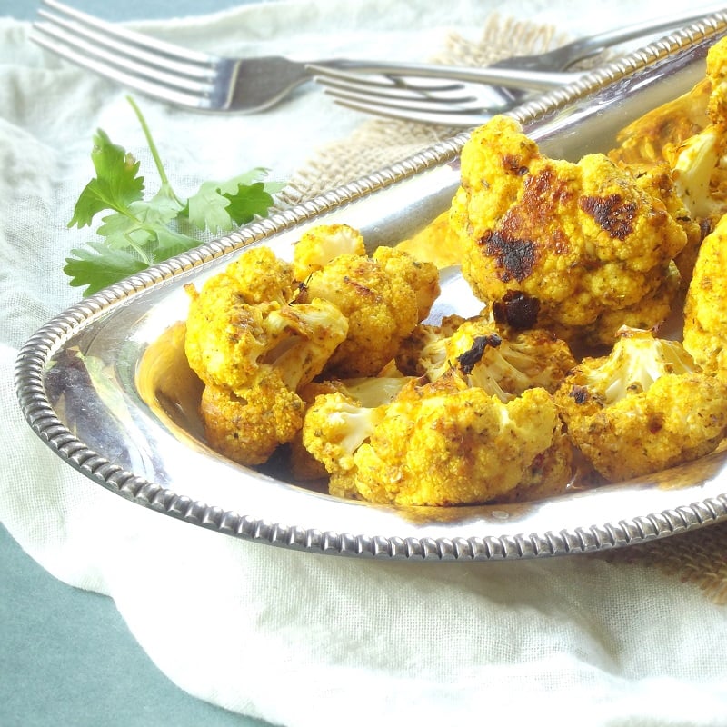 Close Up of a Plate of Cauliflower Tikka with Forks in the Background