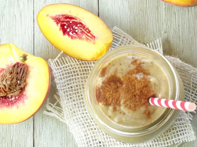 Peach Pie Avocado Smoothie surrounded by cut peaches.