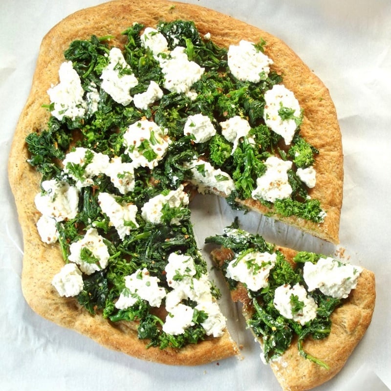 Overhead View of a Whole Vegan Broccoli Rabe Pizza with one Slice Cut Out