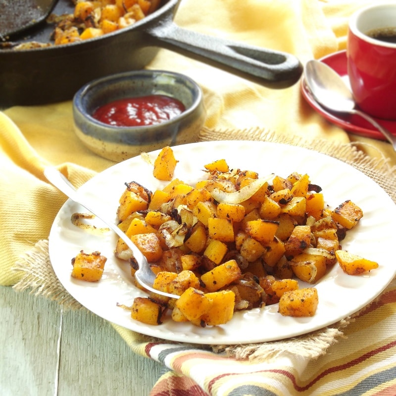 Plate of Butternut Squash Home Fries with Skillet and Dish of Ketchup in the Background