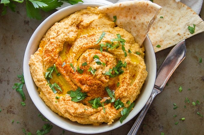 Overhead View of a Bowl of Butternut Squash Hummus with a Pita Bread