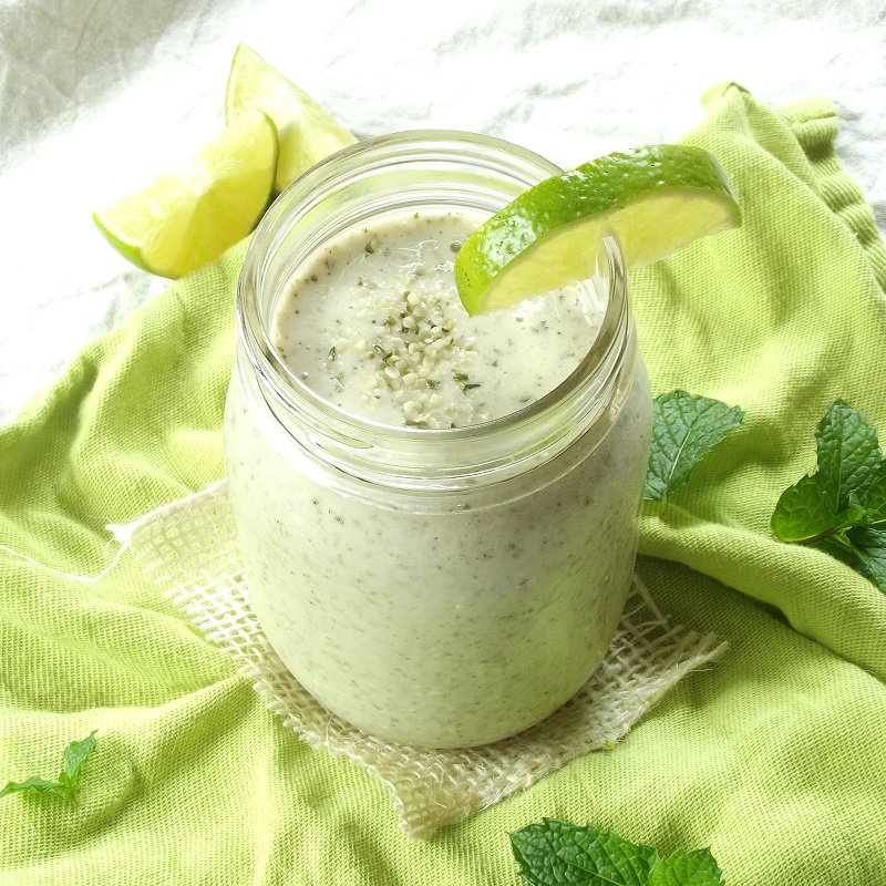 Hemp Mojito Smoothie in a Jar Surrounded by Lime Slices and Mint Leaves