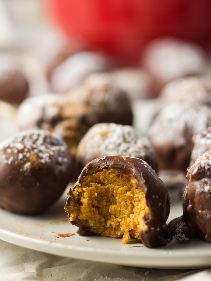 Close Up of Vegan Pumpkin Truffles on a Plate, with a Bite Taken out of One Truffle