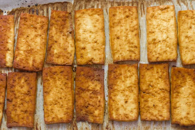 Baked Tofu on a Parchment-Lined Baking Sheet for Making Smoky Baked Tofu Sandwiches with Wasabi Cashew Mayo