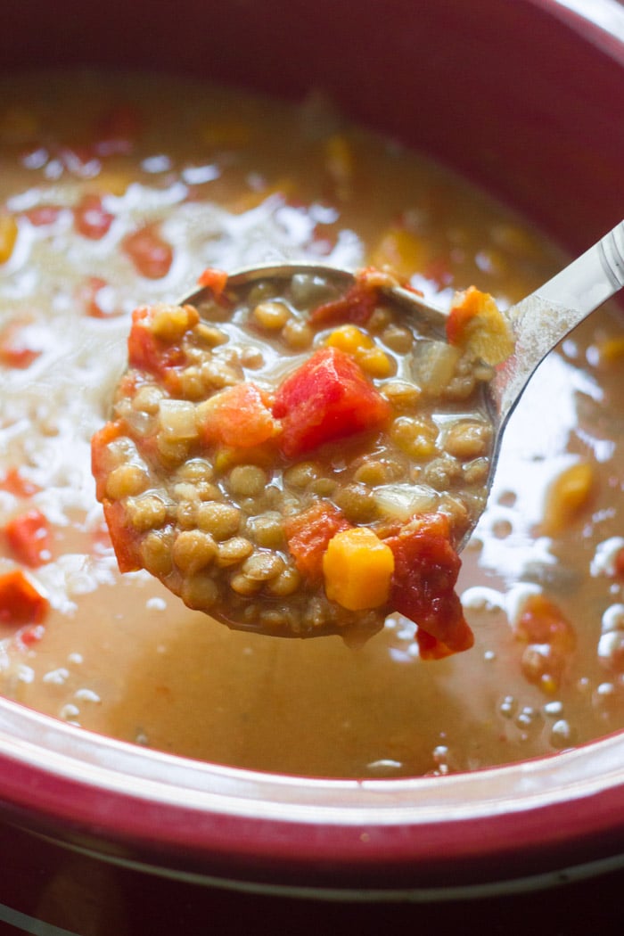 Ladle Drawing Curried Sweet Potato Lentil Soup from a Slow Cooker