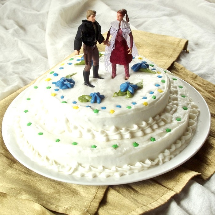 Two Layer Cake on a Plate with Star Wars Figurines on Top
