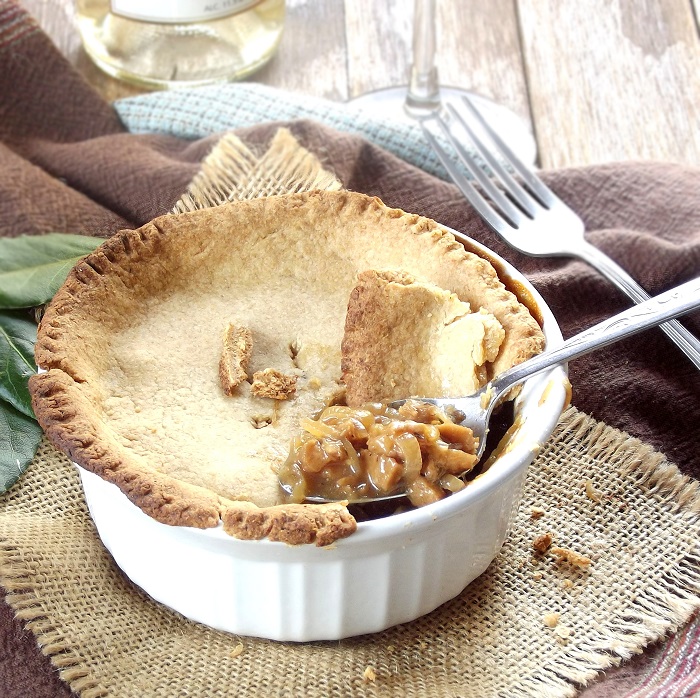 Spoon Scooping Out a Bite of French Onion Pot Pie in a Ramekin