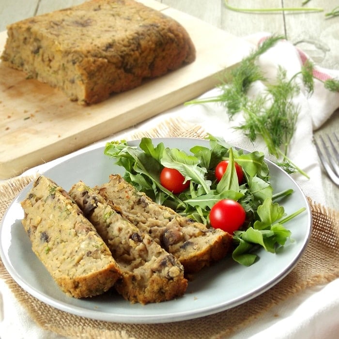 Slices of Lentil Loaf on a Plate with Salad, Cutting Board with the Rest of the Loaf in the Background
