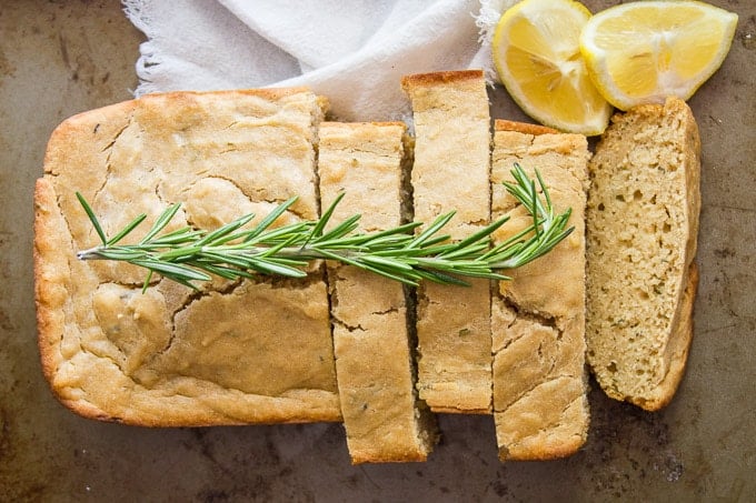 Overhead View of a Rosemary Lemon Vegan Pound Cake Garnished with Fresh Rosemary and Lemon Wedges