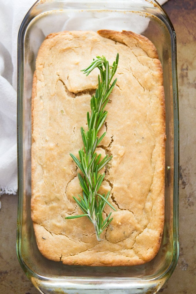 Rosemary Lemon Vegan Pound Cake in a Cake Pan with a Sprig of Rosemary on Top