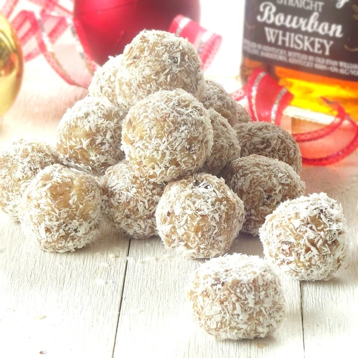 Stack of Vegan Snowballs with Christmas Decorations and Bottle of Bourbon in the Background