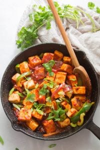 Skillet Filled with Vegan Chilli Paneer Topped with Scallions and Cilantro