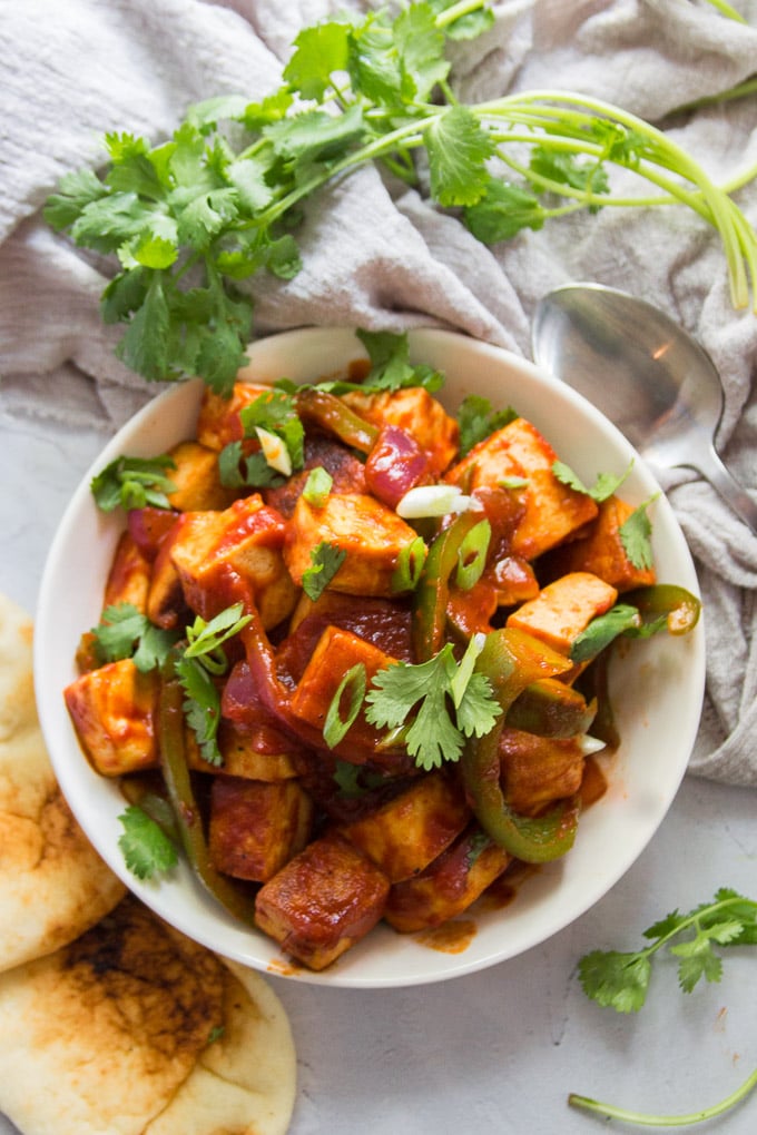 Bowl of Vegan Chilli Paneer with Naan and Serving Spoon