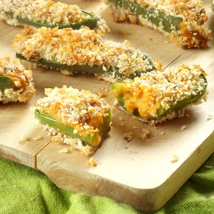 Close Up of Vegan Jalapeno Poppers on a Cutting Board Sitting on Green Fabric