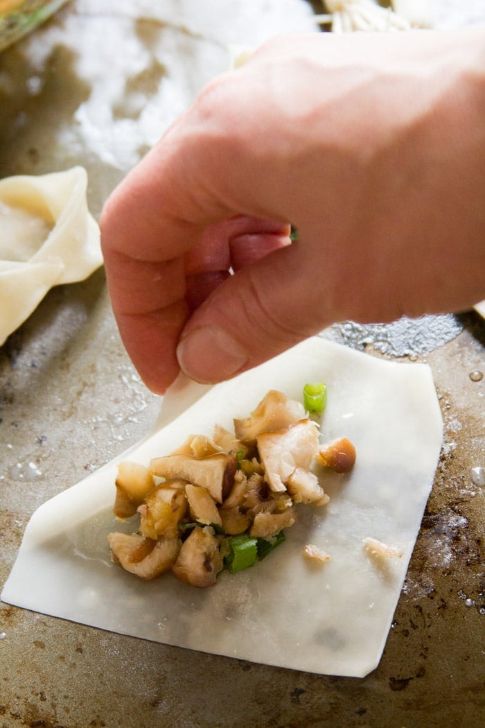 Hand Folding A Wonton Wrapper Over Fillings to Make Vegan Wonton Soup