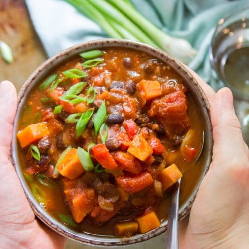 Hands Holding a Bowl of Chipotle Black Bean Sweet Potato Chili