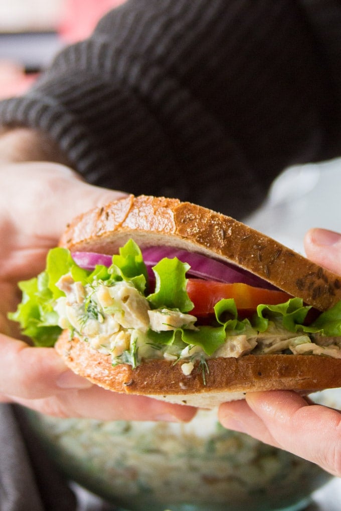 Hands Holding a Vegan Chicken Salad Sandwich