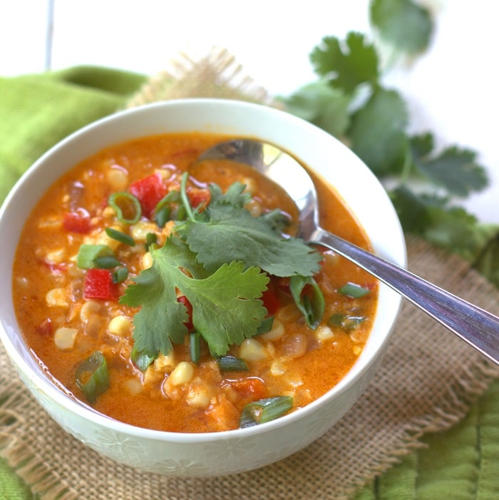 Bowl of red curry corn chowder with cilantro on top.