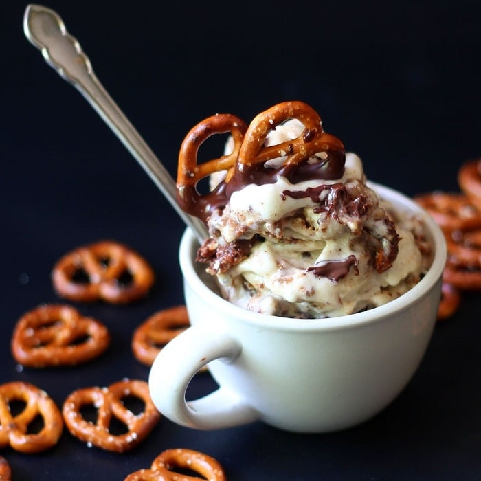 Cup of Chocolate Covered Pretzel Nice Cream on a Black Background with Scattered Mini Pretzels