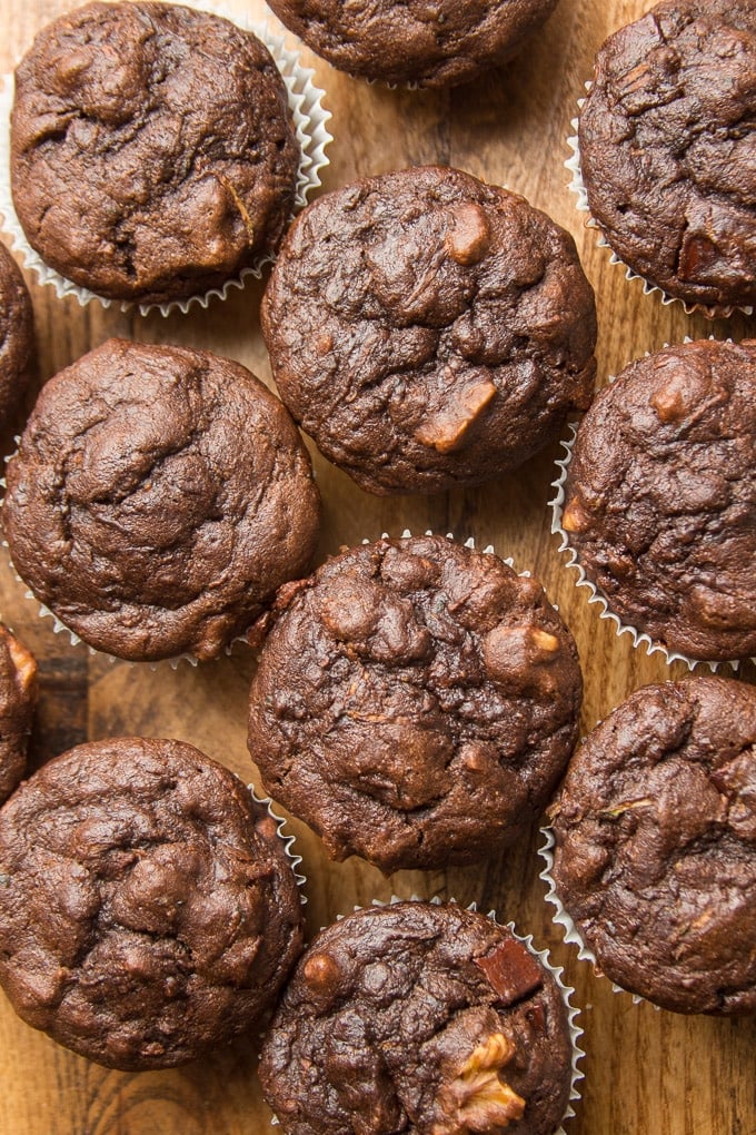 Vegan Chocolate Zucchini Muffins Lined Up on a Wooden Surface