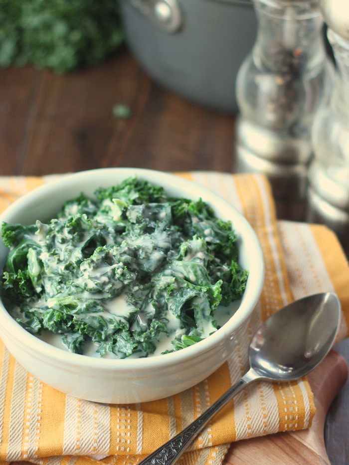 Bowl of Vegan Creamed Kale with Spoon on the Side, Salt and Pepper Shakers in the Background