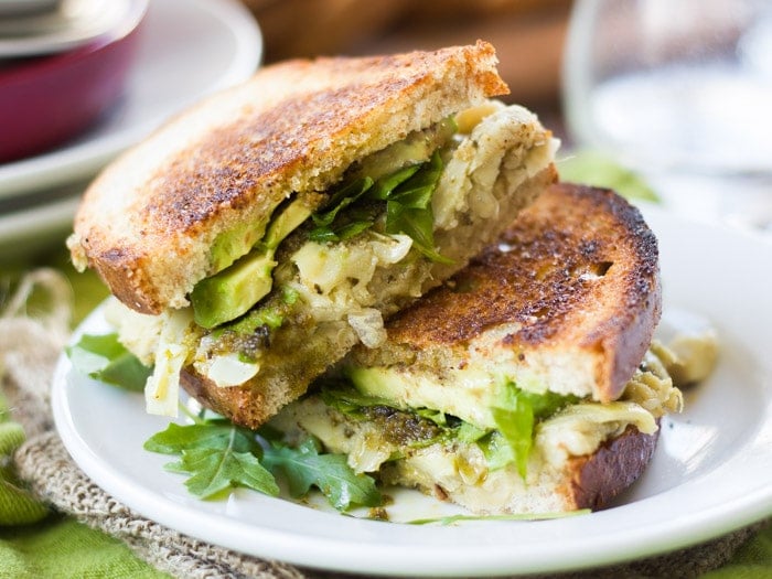 Two Halves of a Vegan Green Goddess Melt Sandwich Stacked on a Plate