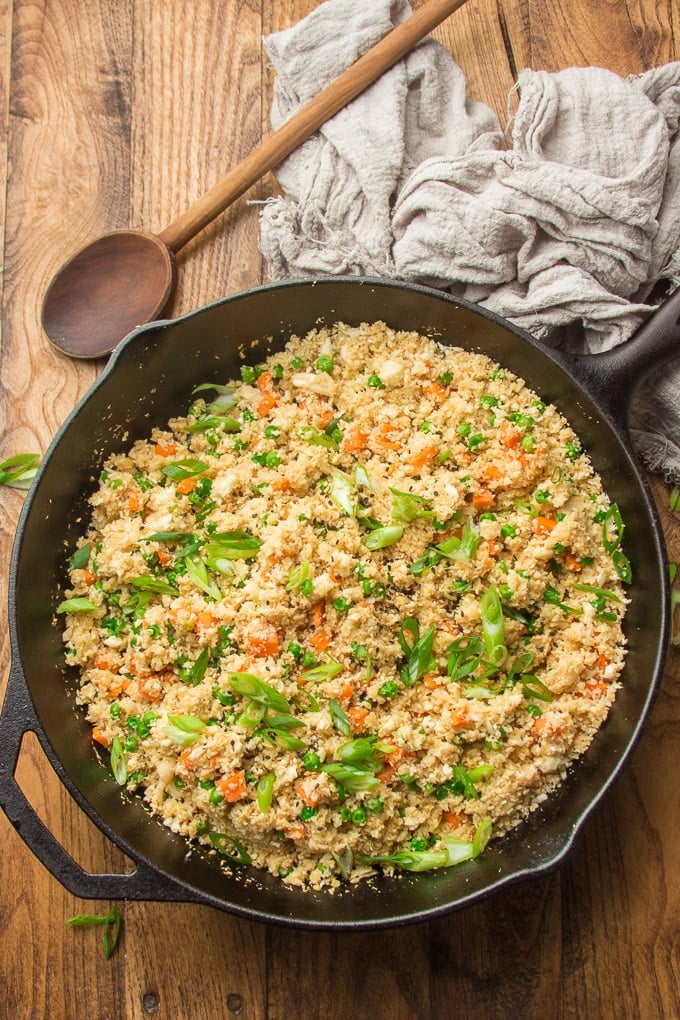 Skillet of Cauliflower Fried Rice with Spoon on a Wooden Surface
