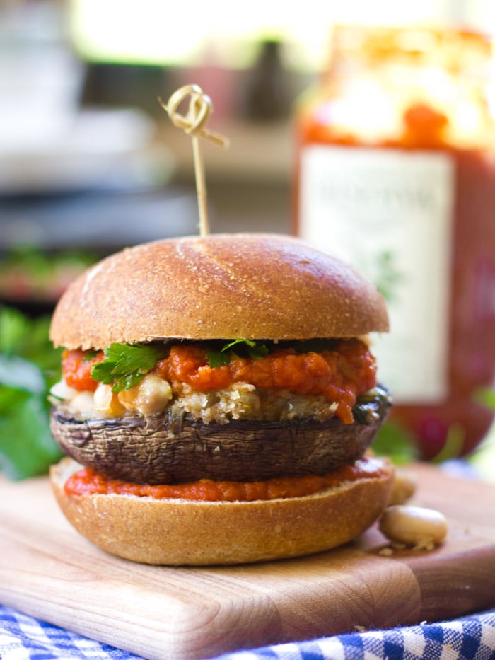 Portobello Puttanesca Burger on a Cutting Board with Jar of Pasta Sauce in the Background