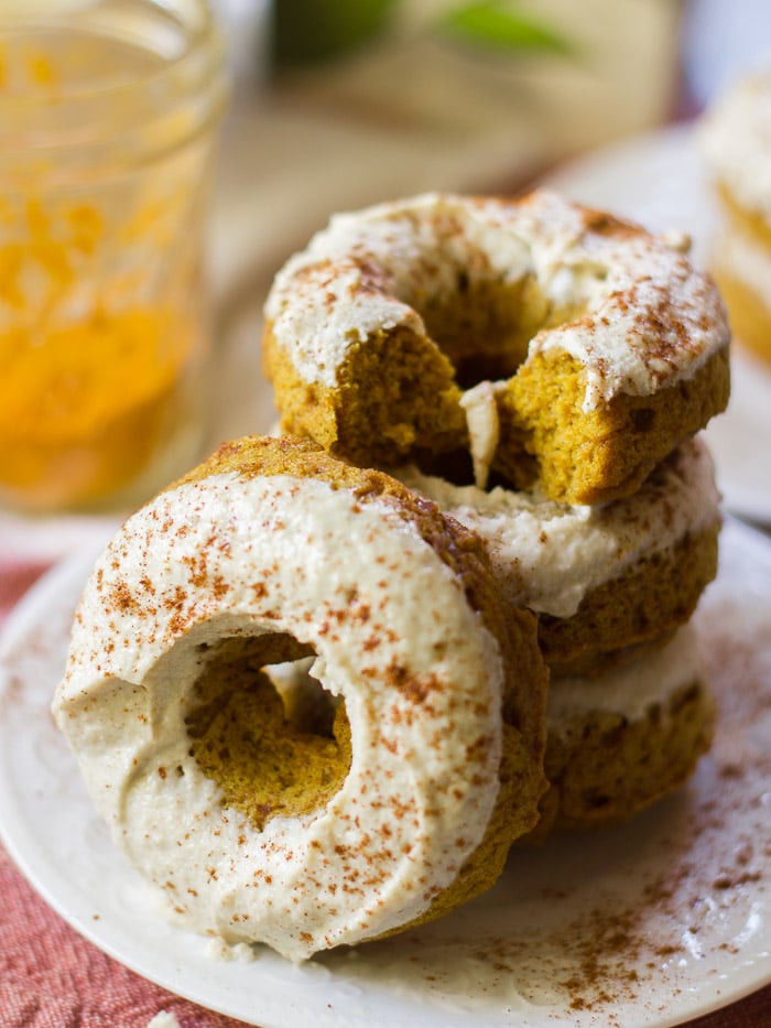 Stack of Vegan Golden Milk Doughnuts with a Jar of Turmeric in the Background