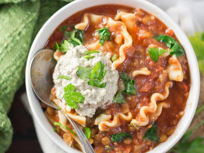 Vegan Slow Cooker Lasagna Soup in a Bowl with Parsley and Vegan Ricotta on Top