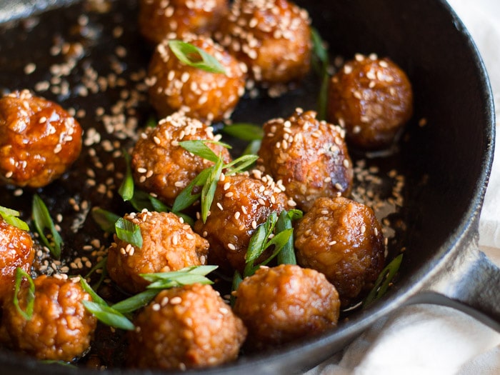 Teriyaki Tempeh Meatballs in a Skillet with Sesame Seeds and Scallions on Top